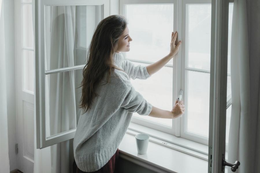 mujer abriendo la ventana