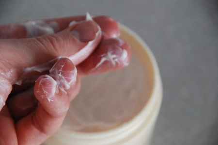 manos con crema hidratante en los dedos